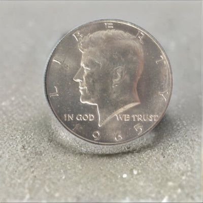 Experience a piece of history with the 1965 Kennedy Half Dollar, the first issue of this iconic coin containing 40% silver. Uncirculated and in wonderful condition, this coin captures the spirit and significance of its first day of release. This coin was not taken out of the package i photo shopped the background in.