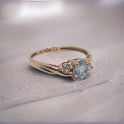 mage of a vintage 10K yellow gold ring with a beautiful blue topaz gemstone and sparkling cubic zirconia accents, in size 6.5